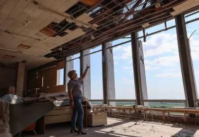 Директорка бібліотеки Надія Коротун показує на місце влучання російських снарядів 2 і 3 серпня 2023 року