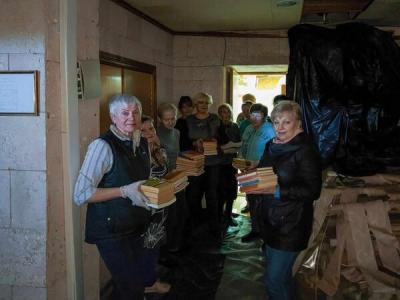Надія Коротун разом з колегами рятують книги, які лишились в бібліотеці.