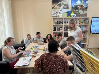 Учасники інклюзивного театру готують паперові фігурки для мультфільму про підводний світ